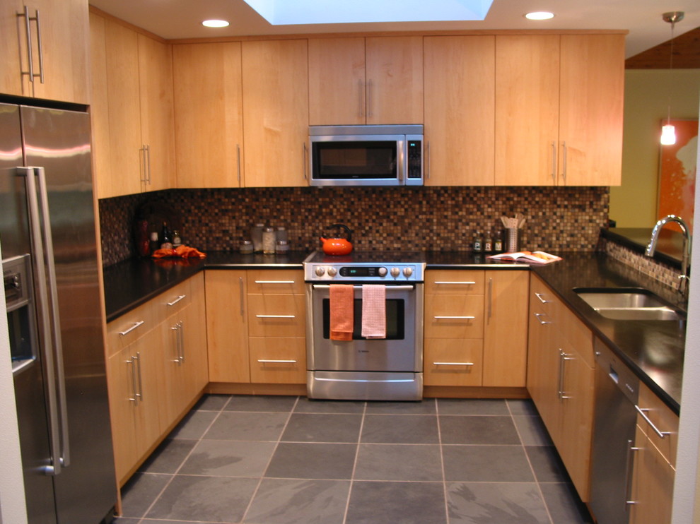 This is an example of a contemporary kitchen in Seattle with an undermount sink, flat-panel cabinets, light wood cabinets, granite benchtops, multi-coloured splashback, stainless steel appliances and slate floors.