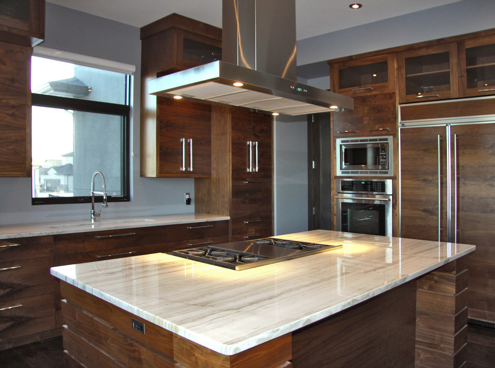 This is an example of a large contemporary u-shaped open plan kitchen in Other with flat-panel cabinets, medium wood cabinets, marble benchtops, panelled appliances, dark hardwood floors, multiple islands, a drop-in sink, white splashback and stone slab splashback.