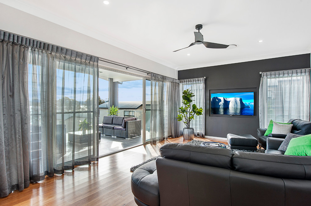 Inspiration for a contemporary living room in Newcastle - Maitland with light hardwood floors and a wall-mounted tv.