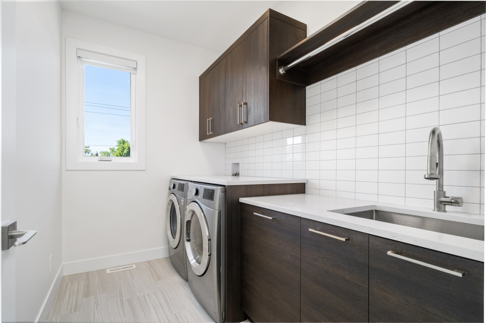 Design ideas for a small transitional single-wall dedicated laundry room in Calgary with an undermount sink, shaker cabinets, dark wood cabinets, quartzite benchtops, white splashback, ceramic splashback, white walls, ceramic floors, a side-by-side washer and dryer, beige floor and white benchtop.