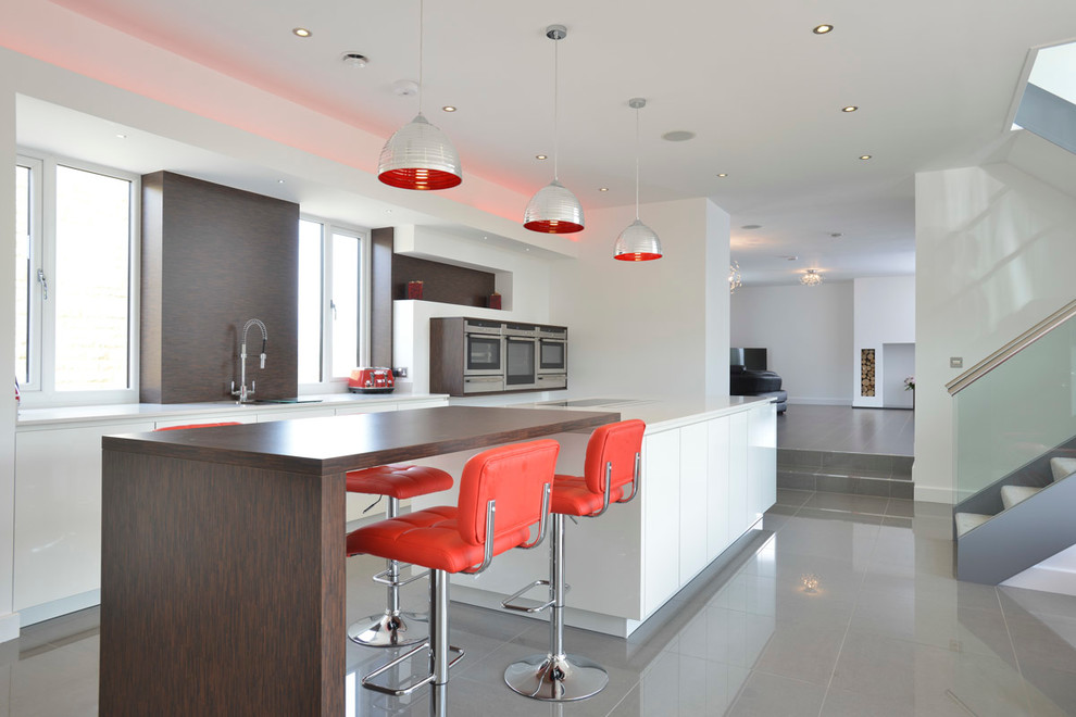 Contemporary kitchen in Manchester with flat-panel cabinets, white cabinets, stainless steel appliances and with island.