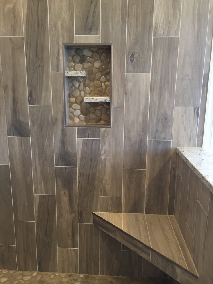 Example of a large transitional master gray tile and porcelain tile light wood floor and brown floor freestanding bathtub design in Baltimore with shaker cabinets, dark wood cabinets, a two-piece toilet, beige walls, an undermount sink, solid surface countertops and a hinged shower door