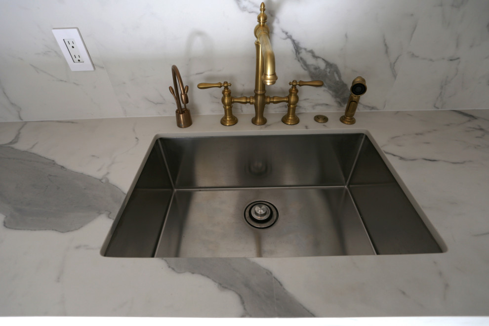 Inspiration for a mid-sized transitional l-shaped marble floor, white floor and exposed beam kitchen remodel in DC Metro with an undermount sink, shaker cabinets, white cabinets, quartzite countertops, white backsplash, quartz backsplash and stainless steel appliances