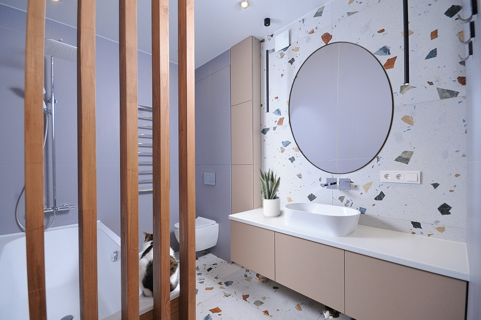 Design ideas for a medium sized contemporary ensuite bathroom in Moscow with flat-panel cabinets, beige cabinets, an alcove bath, a wall mounted toilet, blue tiles, porcelain tiles, blue walls, terrazzo flooring, a built-in sink, solid surface worktops, white worktops, feature lighting, a single sink and a floating vanity unit.