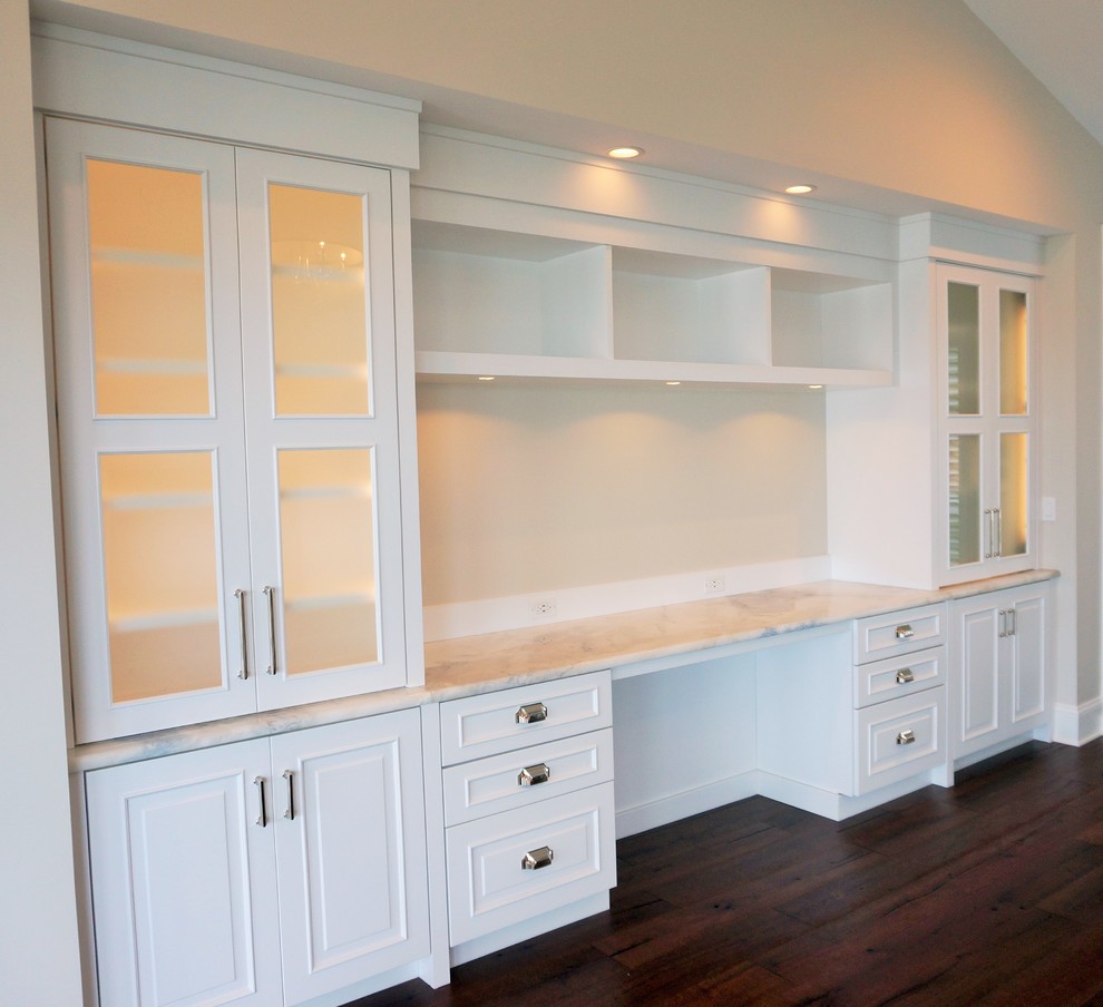 Home office - mid-sized transitional built-in desk medium tone wood floor home office idea in Jacksonville with beige walls