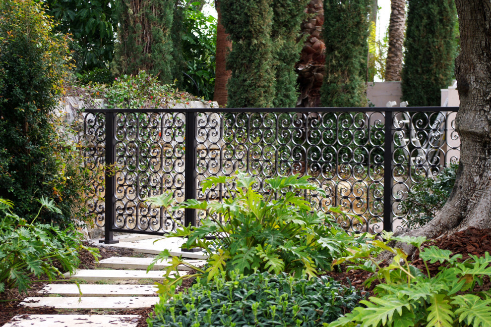 Idée de décoration pour un jardin asiatique avec une clôture en métal.