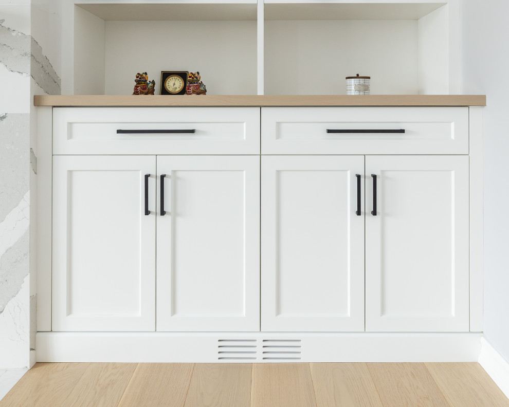 Inspiration for a mid-sized transitional light wood floor open concept kitchen remodel in Toronto with shaker cabinets, white cabinets, wood countertops, quartz backsplash and an island