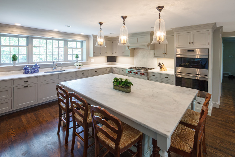 Kitchen - large transitional l-shaped dark wood floor kitchen idea in Boston with a single-bowl sink, beaded inset cabinets, gray cabinets, marble countertops, gray backsplash, stone slab backsplash, paneled appliances and an island