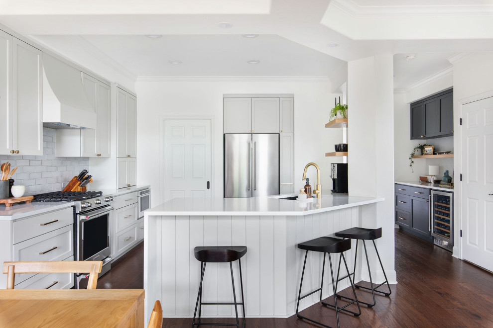 Example of a mid-sized transitional medium tone wood floor and brown floor kitchen design in Austin with an undermount sink, shaker cabinets, gray cabinets, quartz countertops, white backsplash, brick backsplash and white countertops