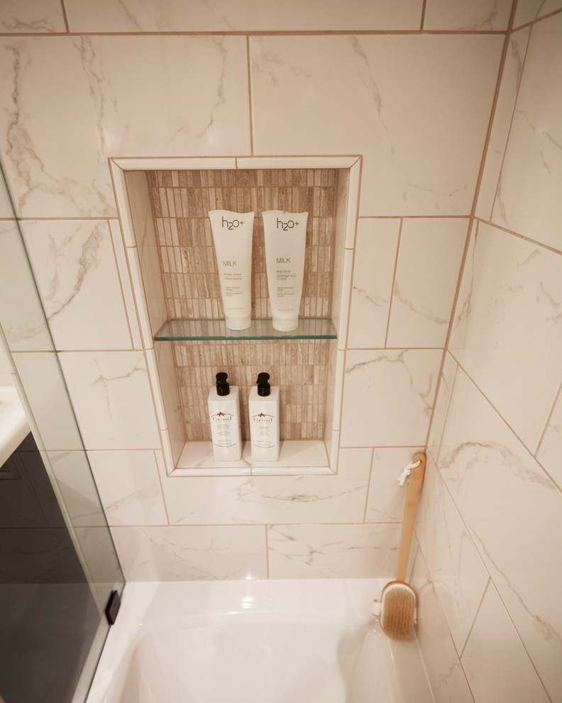 This is an example of a small traditional bathroom in Milwaukee with shaker cabinets, dark wood cabinets, a drop-in tub, an alcove shower, a two-piece toilet, white tile, white walls, marble floors, a drop-in sink, solid surface benchtops, brown floor, marble and a hinged shower door.