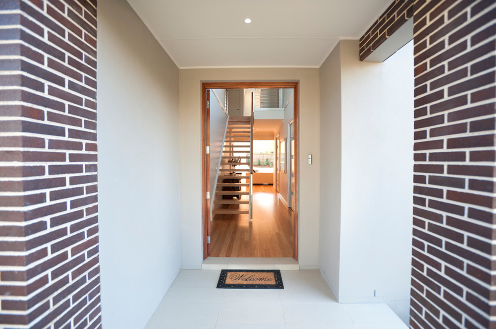 This is an example of a contemporary front door in Melbourne with white walls, granite floors, a double front door, a light wood front door and white floor.