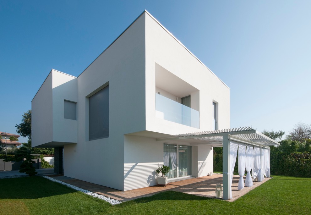 This is an example of a large contemporary two-storey white exterior in Venice with a flat roof.