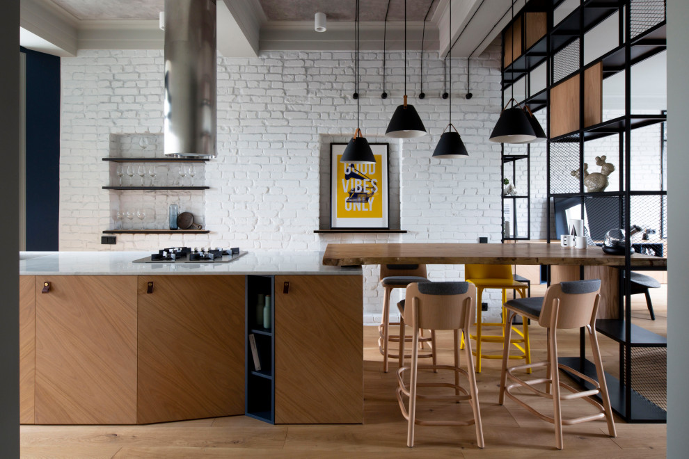 Идея дизайна: кухня-гостиная в стиле лофт с плоскими фасадами, фасадами цвета дерева среднего тона и островом