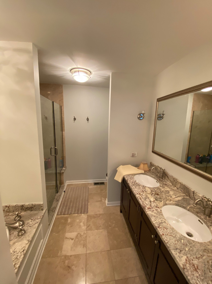 Exempel på ett mellanstort lantligt flerfärgad flerfärgat en-suite badrum, med luckor med upphöjd panel, skåp i mörkt trä, ett hörnbadkar, en dubbeldusch, en toalettstol med hel cisternkåpa, vit kakel, marmorkakel, vita väggar, mosaikgolv, ett konsol handfat, granitbänkskiva, brunt golv och dusch med gångjärnsdörr