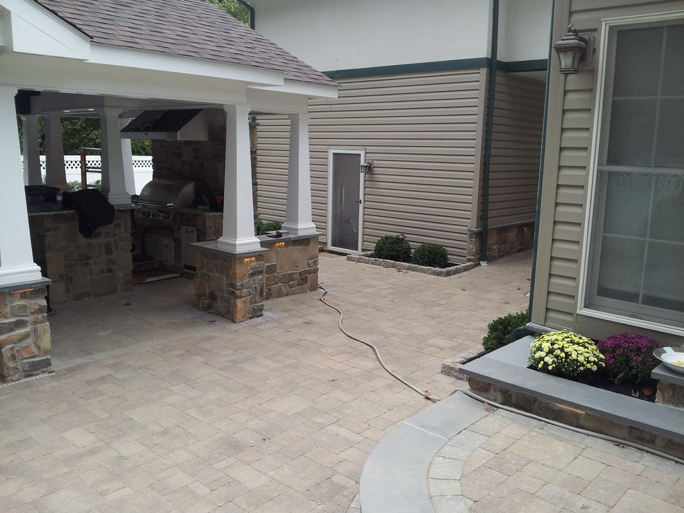 Expansive traditional backyard patio in Philadelphia with an outdoor kitchen, concrete pavers and a gazebo/cabana.