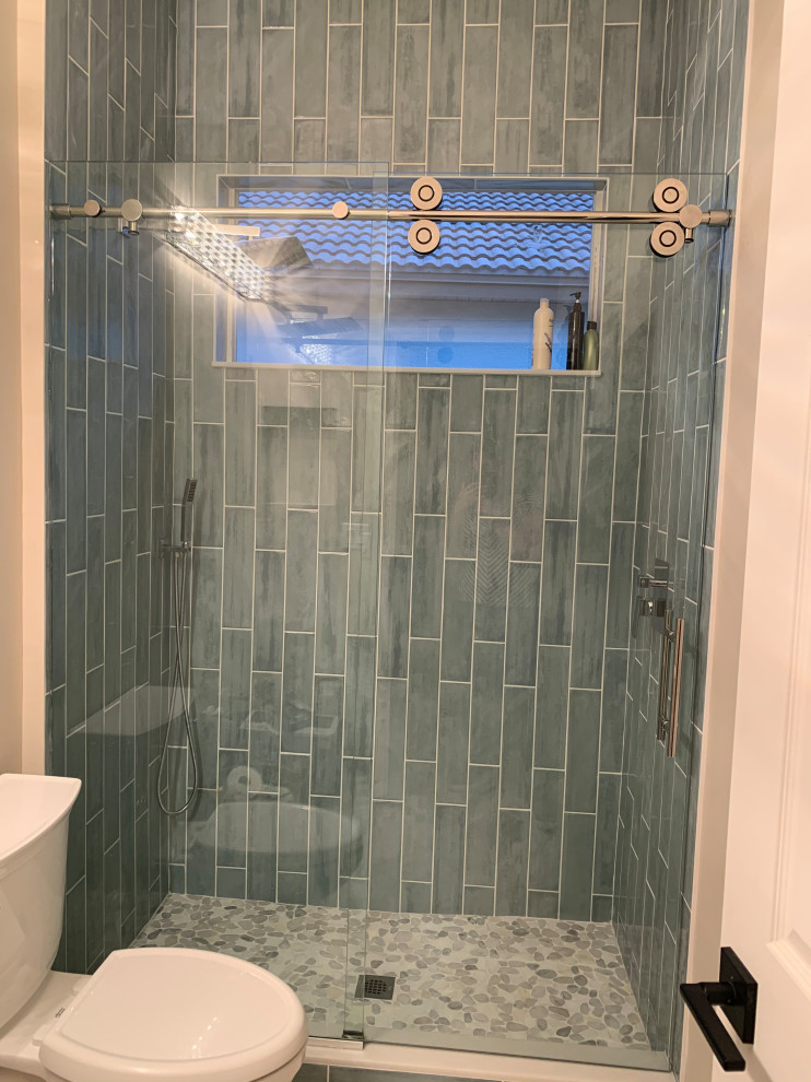 This is an example of a small beach style 3/4 bathroom in Miami with shaker cabinets, white cabinets, an alcove shower, a two-piece toilet, blue tile, subway tile, white walls, porcelain floors, an undermount sink, engineered quartz benchtops, multi-coloured floor, a sliding shower screen, white benchtops, a single vanity and a floating vanity.