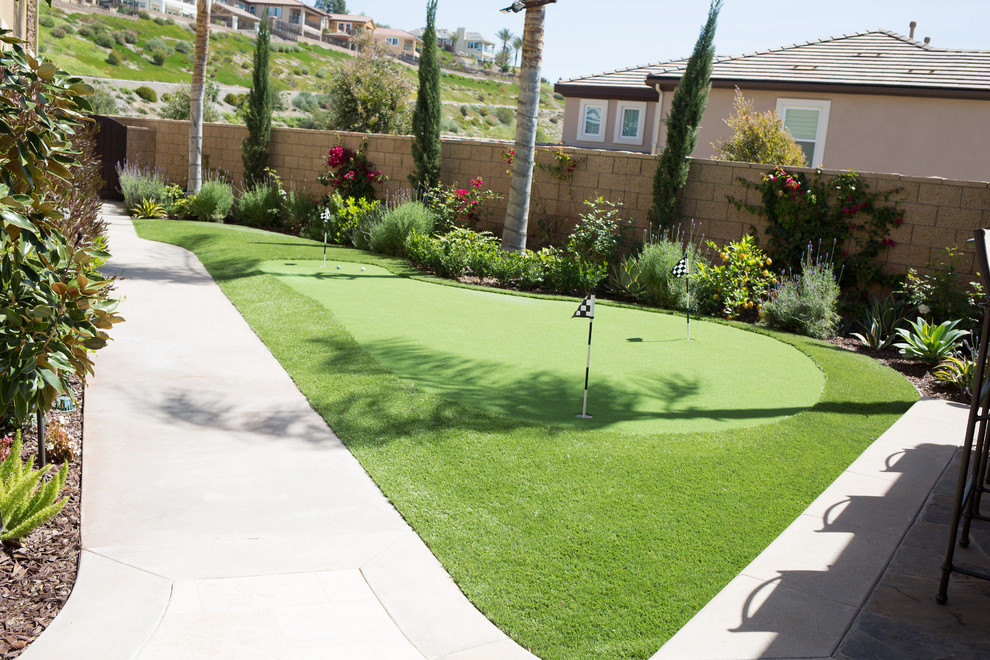 This is an example of a large traditional backyard partial sun xeriscape in Orange County with natural stone pavers.