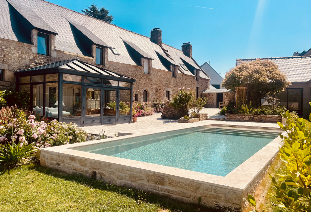 This is an example of a medium sized farmhouse back rectangular swimming pool in Rennes with with pool landscaping.