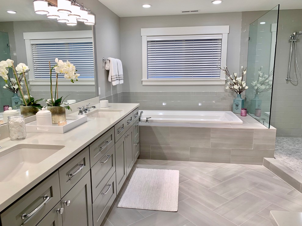 Transitional bathroom in Other with recessed-panel cabinets, grey cabinets, a drop-in tub, a corner shower, gray tile, grey walls, an undermount sink, grey floor, an open shower and white benchtops.