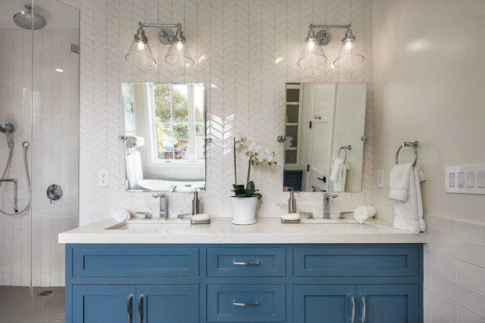 Inspiration for a mid-sized country master bathroom in San Francisco with shaker cabinets, blue cabinets, a freestanding tub, a corner shower, a one-piece toilet, white tile, ceramic tile, white walls, porcelain floors, an undermount sink, engineered quartz benchtops, grey floor, a hinged shower door and white benchtops.