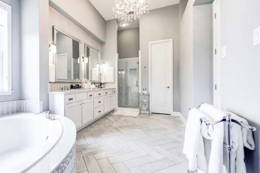 Inspiration for a large contemporary master bathroom in Austin with shaker cabinets, white cabinets, a corner tub, white tile, white walls, laminate floors, an undermount sink, engineered quartz benchtops and white floor.