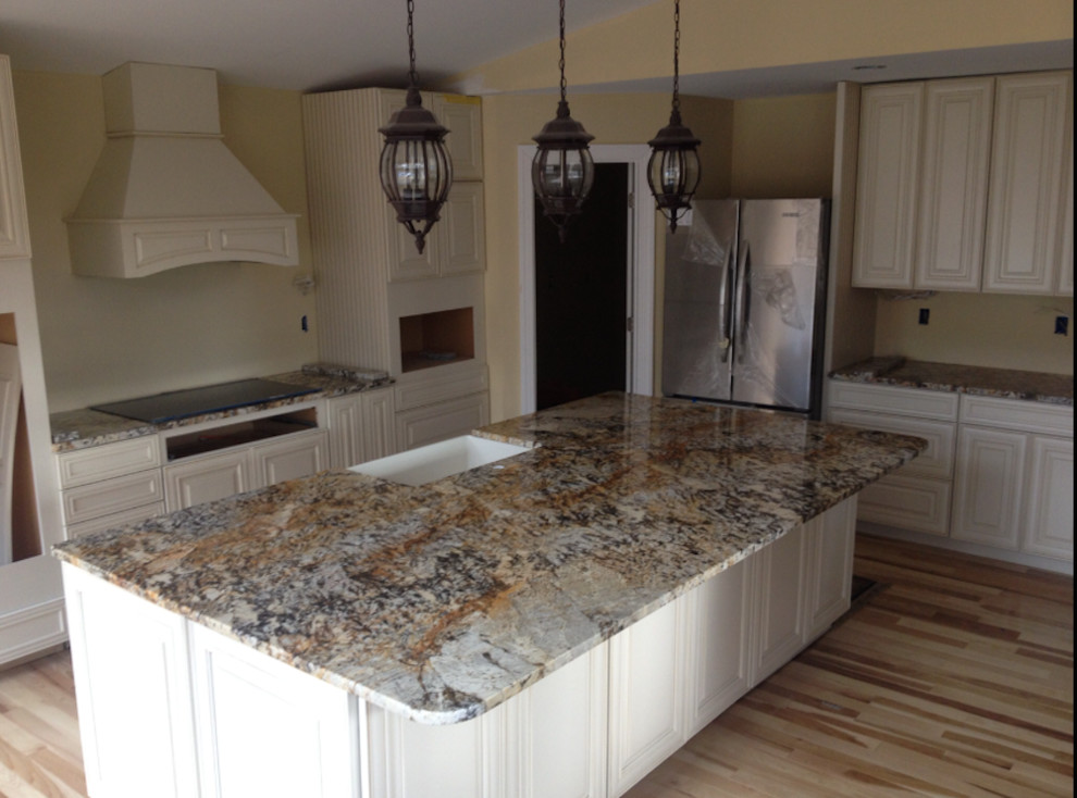 Light wood floor kitchen photo in DC Metro with a farmhouse sink, beaded inset cabinets, white cabinets, granite countertops, stainless steel appliances and an island