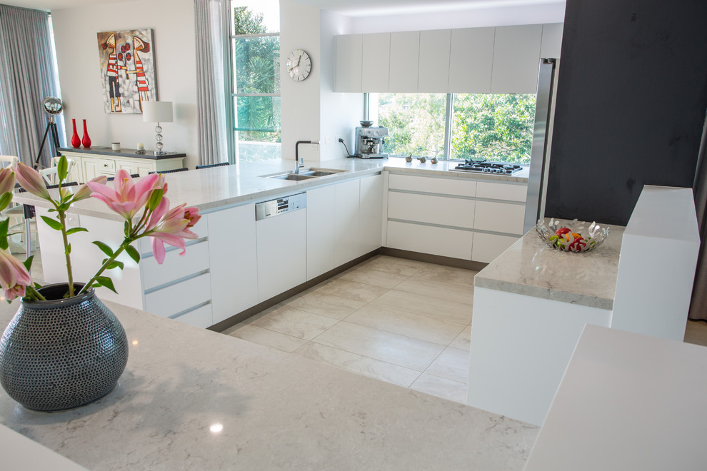 Design ideas for a large modern u-shaped open plan kitchen in Brisbane with a double-bowl sink, recessed-panel cabinets, white cabinets, solid surface benchtops, stainless steel appliances, porcelain floors, multiple islands, brown floor and brown benchtop.