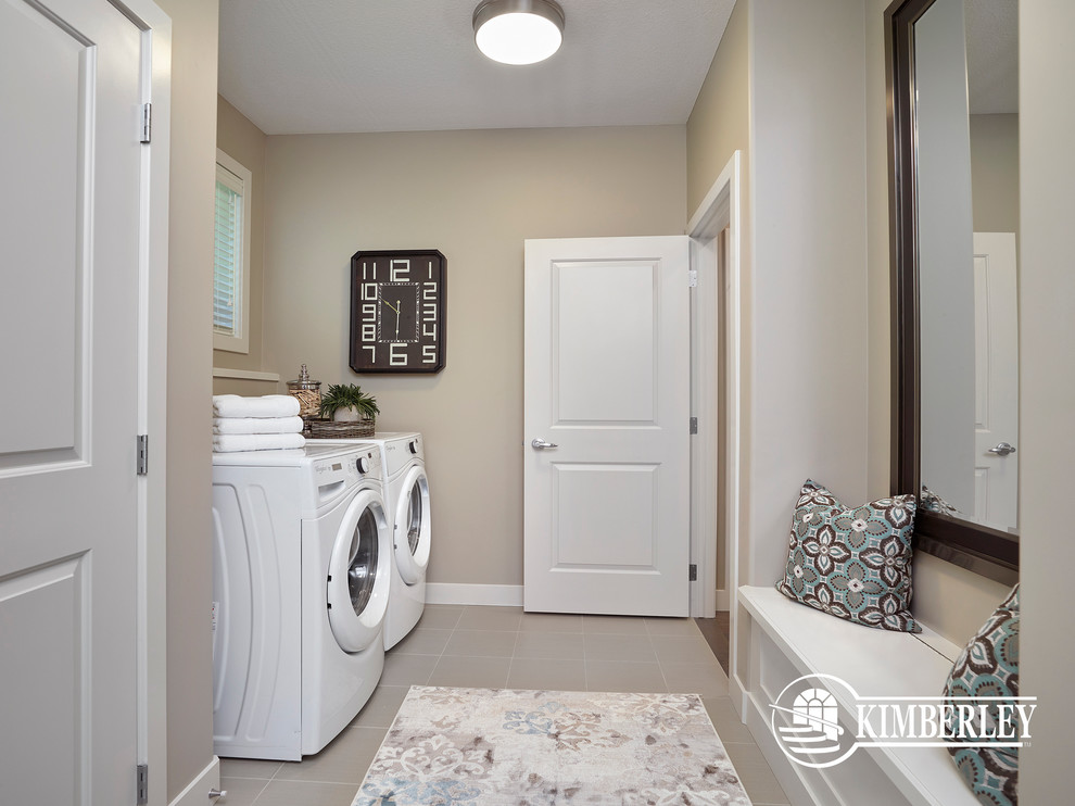 This is an example of a mid-sized contemporary single-wall utility room in Edmonton with beige walls, ceramic floors and a side-by-side washer and dryer.