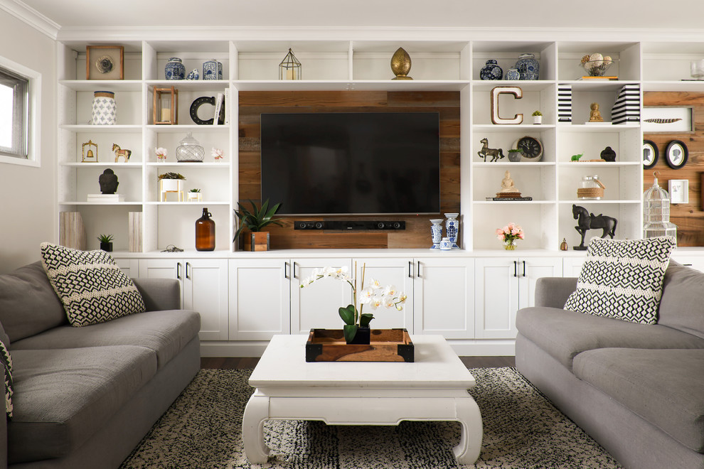 This is an example of a country open concept living room in New York with a built-in media wall, grey walls, dark hardwood floors and brown floor.