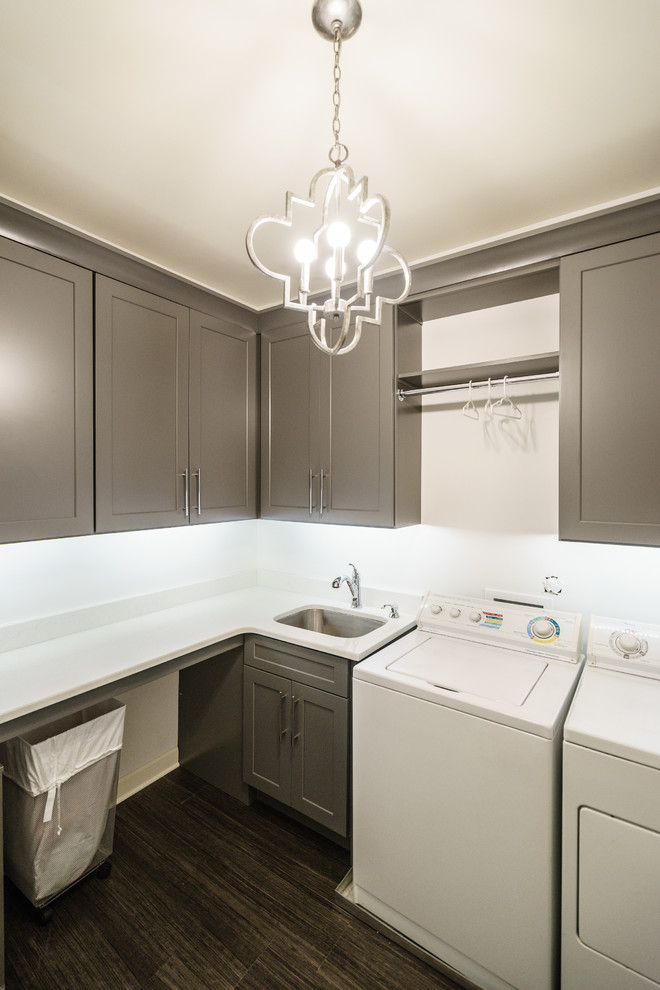 This is an example of a large contemporary l-shaped dedicated laundry room in Raleigh with an undermount sink, shaker cabinets, grey cabinets, quartzite benchtops, grey walls, vinyl floors and a side-by-side washer and dryer.