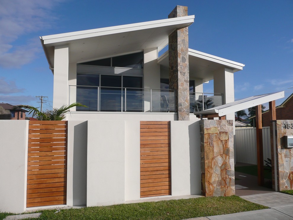Design ideas for a large contemporary two-storey stucco white house exterior in Newcastle - Maitland with a shed roof and a metal roof.