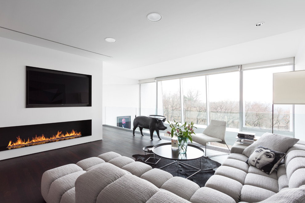 Inspiration for a contemporary open concept living room in New York with white walls, dark hardwood floors, a ribbon fireplace, a stone fireplace surround, a wall-mounted tv and brown floor.