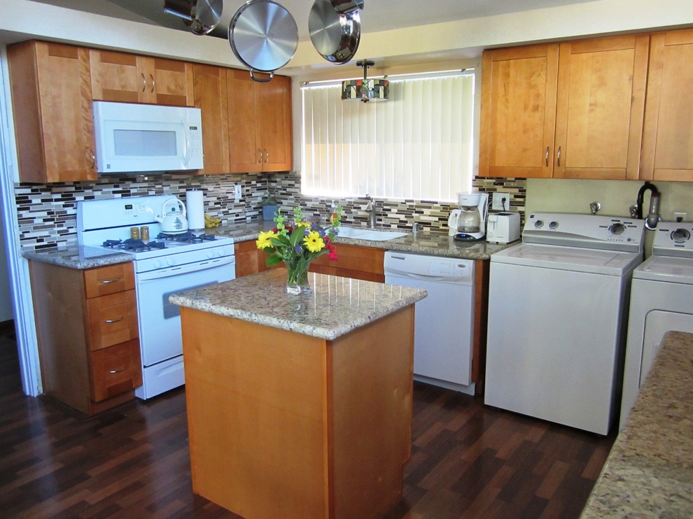 Photo of a mid-sized arts and crafts l-shaped eat-in kitchen in Los Angeles with a double-bowl sink, light wood cabinets, granite benchtops, multi-coloured splashback, glass tile splashback, white appliances, dark hardwood floors, with island and flat-panel cabinets.