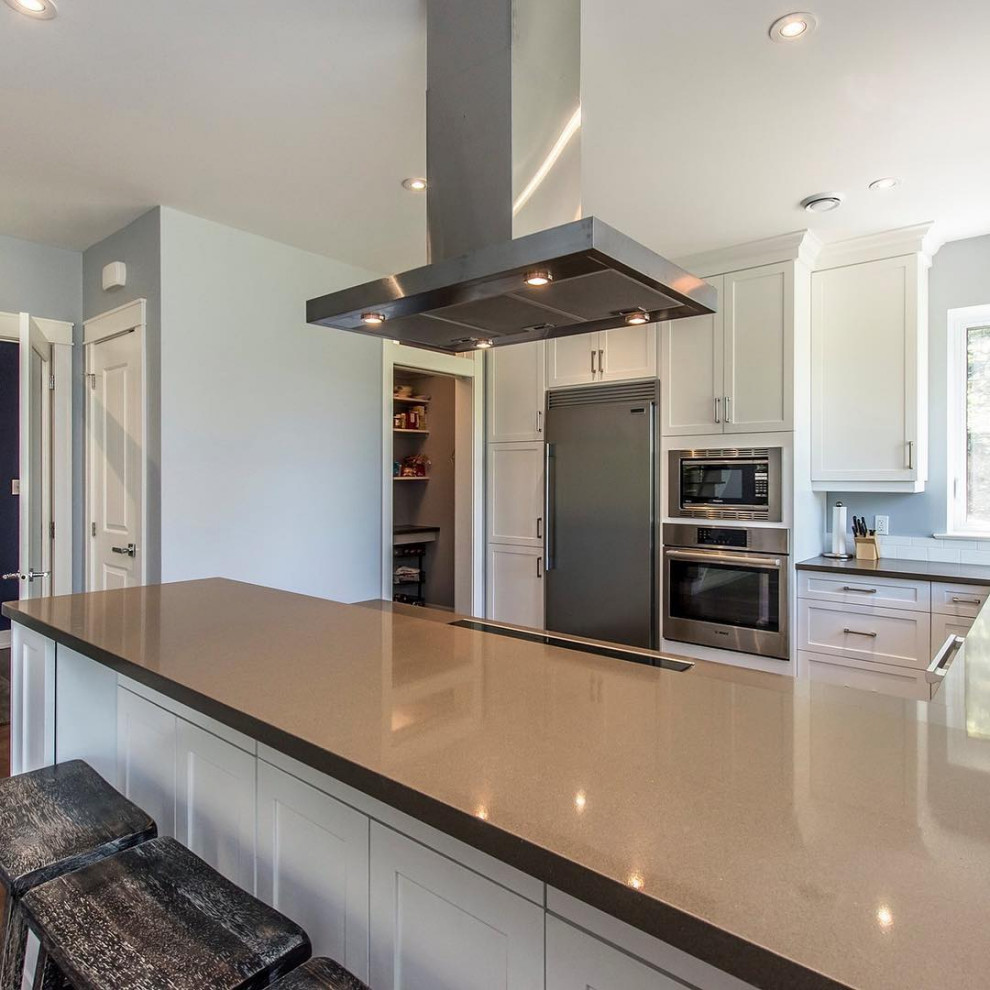 Kitchen - mid-sized u-shaped medium tone wood floor and brown floor kitchen idea with an undermount sink, recessed-panel cabinets, white cabinets, quartzite countertops, white backsplash, subway tile backsplash, stainless steel appliances, no island and brown countertops
