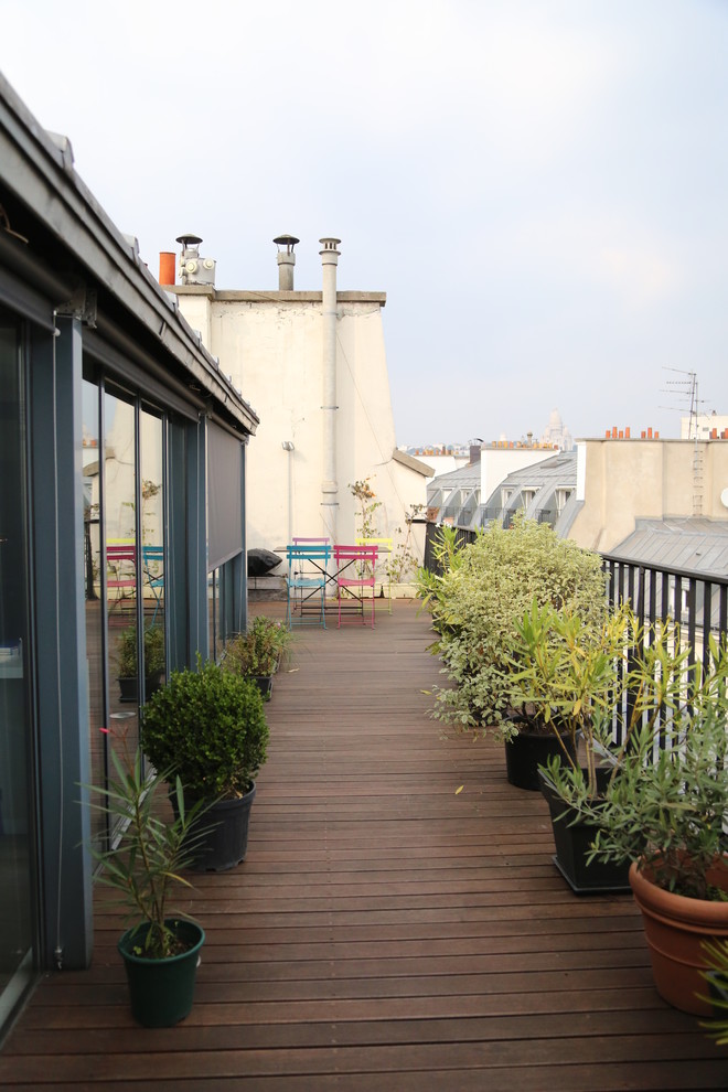 This is an example of an eclectic rooftop and rooftop deck in Paris with no cover.