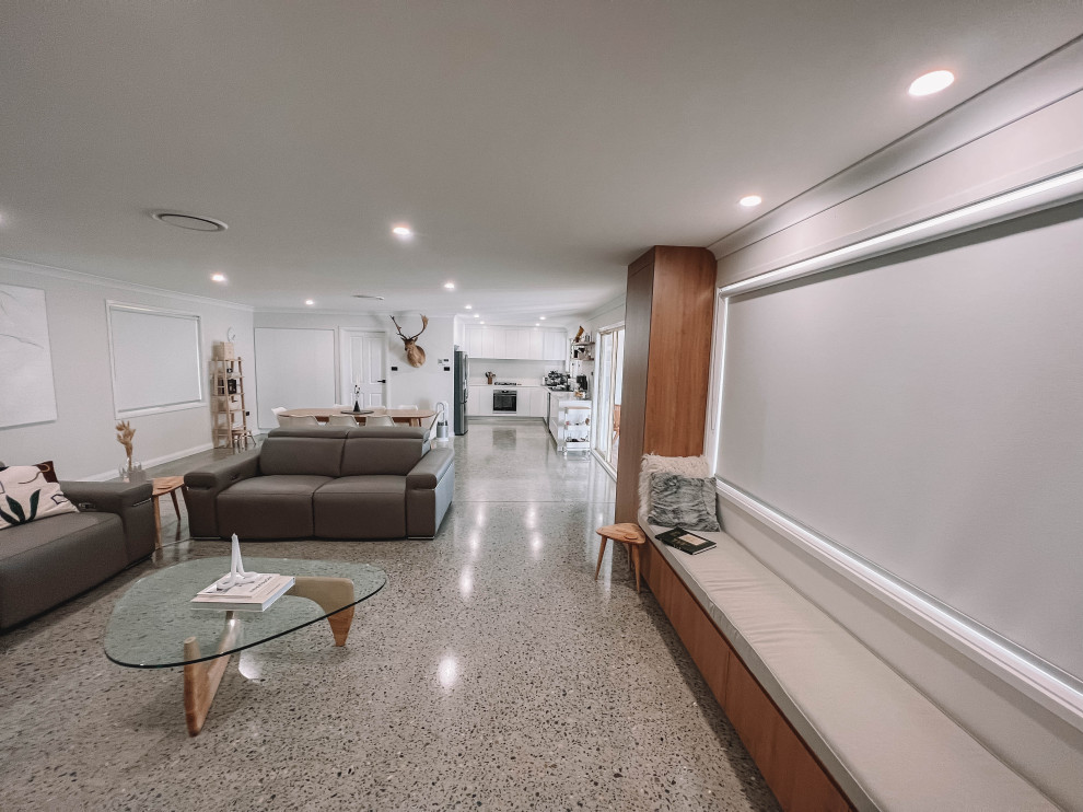 Ejemplo de salón abierto nórdico de tamaño medio con paredes blancas, suelo de cemento, televisor independiente, suelo gris, madera y madera