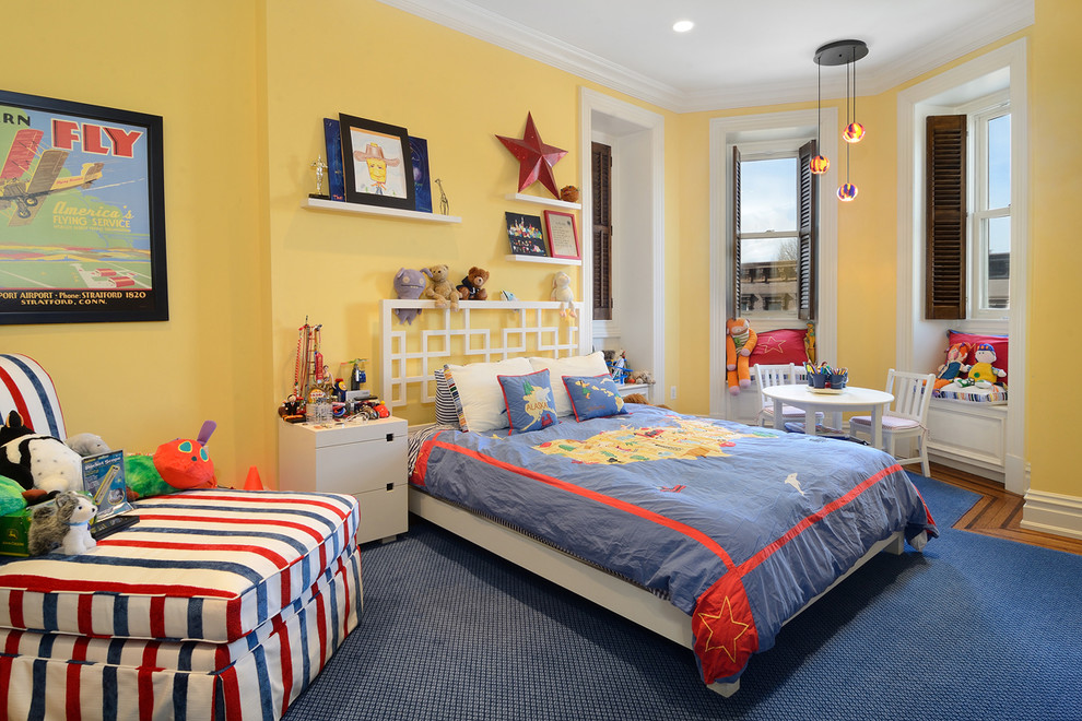 This is an example of a traditional kids' bedroom for kids 4-10 years old and boys in New York with yellow walls, carpet and blue floor.