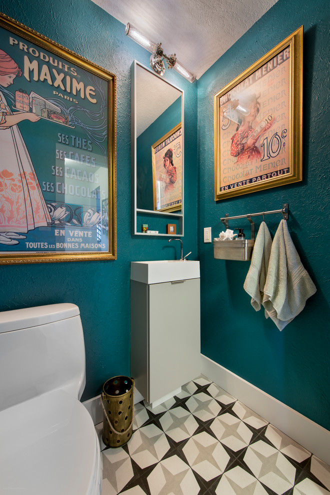 Example of a small eclectic porcelain tile and multicolored floor powder room design in Denver with a one-piece toilet, blue walls, flat-panel cabinets, gray cabinets and a console sink