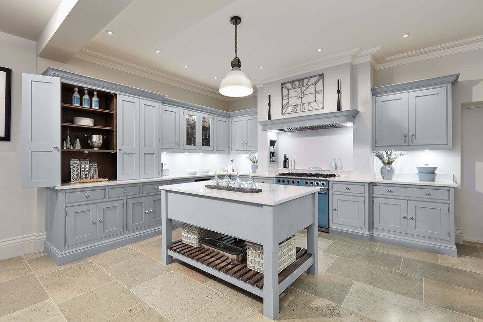 Large transitional l-shaped kitchen in London with shaker cabinets, blue cabinets, quartzite benchtops, white splashback, coloured appliances, limestone floors, with island, multi-coloured floor and white benchtop.