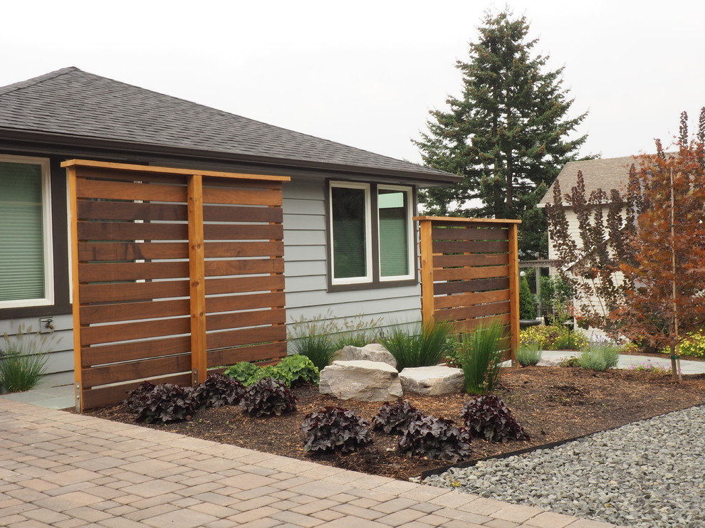 This is an example of a large modern front yard full sun driveway in Portland with concrete pavers.