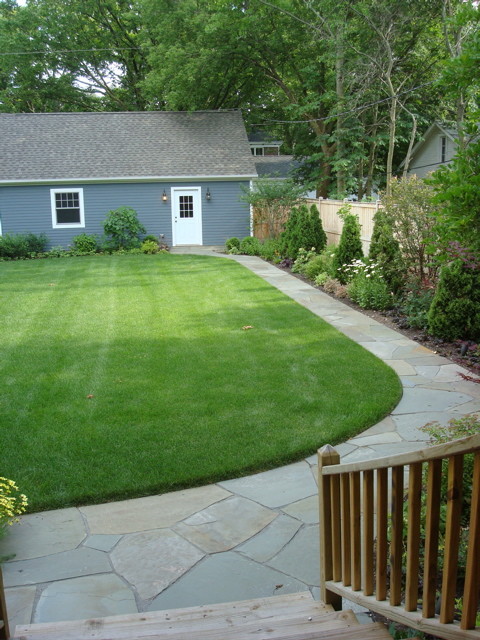 Photo of a mid-sized transitional backyard patio in Chicago with natural stone pavers and no cover.