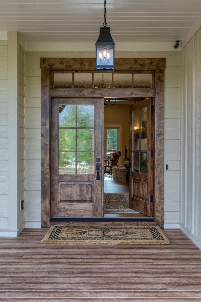 Expansive country front door in Other with beige walls, medium hardwood floors, a double front door, a medium wood front door and brown floor.