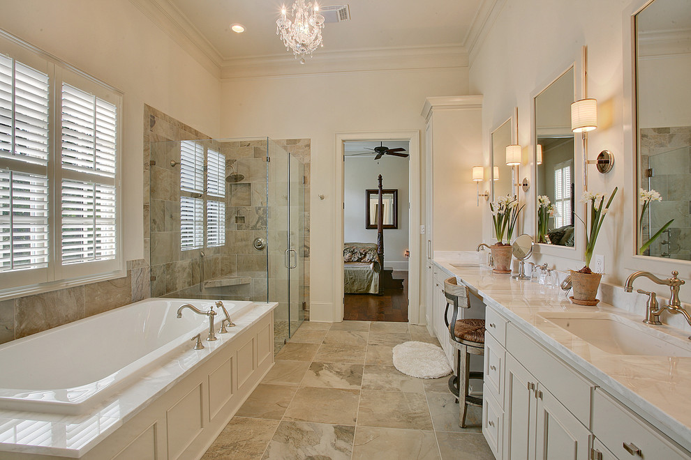 Photo of a mid-sized traditional master bathroom in New Orleans with shaker cabinets, grey cabinets, a drop-in tub, a corner shower, gray tile, porcelain tile, porcelain floors, an undermount sink, marble benchtops and beige walls.
