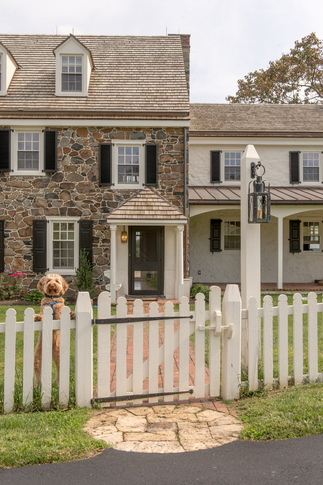 Design ideas for an expansive country three-storey white exterior in Philadelphia with stone veneer and a gable roof.