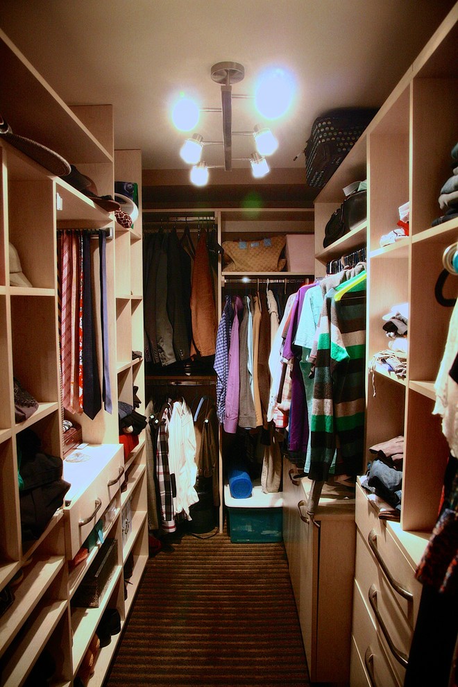 This is an example of a small contemporary gender-neutral walk-in wardrobe in Other with flat-panel cabinets, white cabinets and carpet.