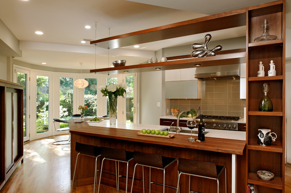 Eat-in kitchen - transitional eat-in kitchen idea in DC Metro with an undermount sink, flat-panel cabinets, dark wood cabinets, brown backsplash, stainless steel appliances and glass tile backsplash