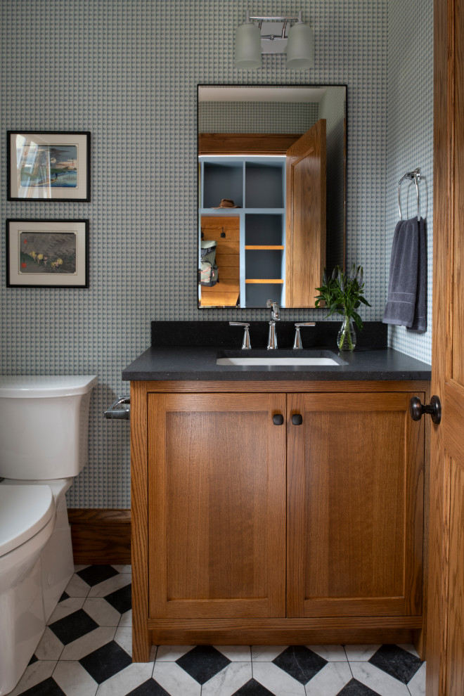 Exemple d'une petite salle de bain craftsman en bois brun avec un placard à porte plane, WC séparés, un mur beige, un sol en carrelage de céramique, un lavabo encastré, un plan de toilette en granite, une cabine de douche à porte battante, un plan de toilette noir, meuble simple vasque, meuble-lavabo sur pied et du papier peint.