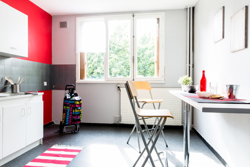 Idées déco pour une cuisine américaine linéaire contemporaine de taille moyenne avec sol en béton ciré, un placard à porte plane, des portes de placard blanches, une crédence grise et aucun îlot.