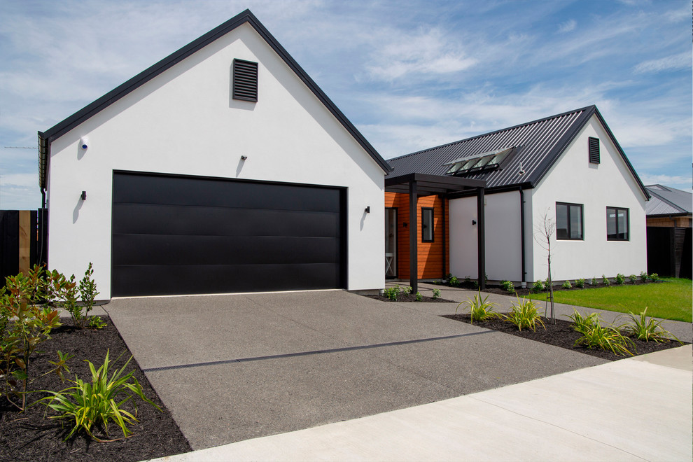 Design ideas for a large modern one-storey stucco multi-coloured house exterior in Christchurch with a gable roof and a metal roof.
