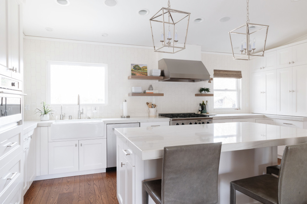 Exempel på ett mellanstort klassiskt vit vitt kök, med en rustik diskho, skåp i shakerstil, vita skåp, bänkskiva i kvartsit, vitt stänkskydd, stänkskydd i keramik, rostfria vitvaror, mellanmörkt trägolv, en köksö och brunt golv